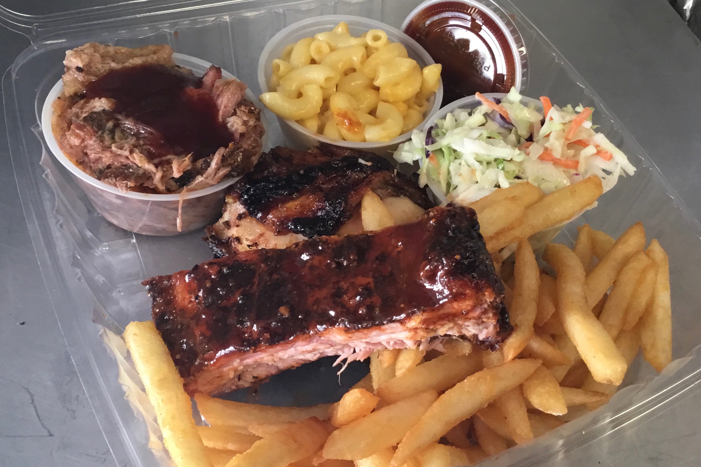 1 BBQ rib, 1 piece dark chicken, pulled pork, 2 sides, fries and BBQ sauce.
