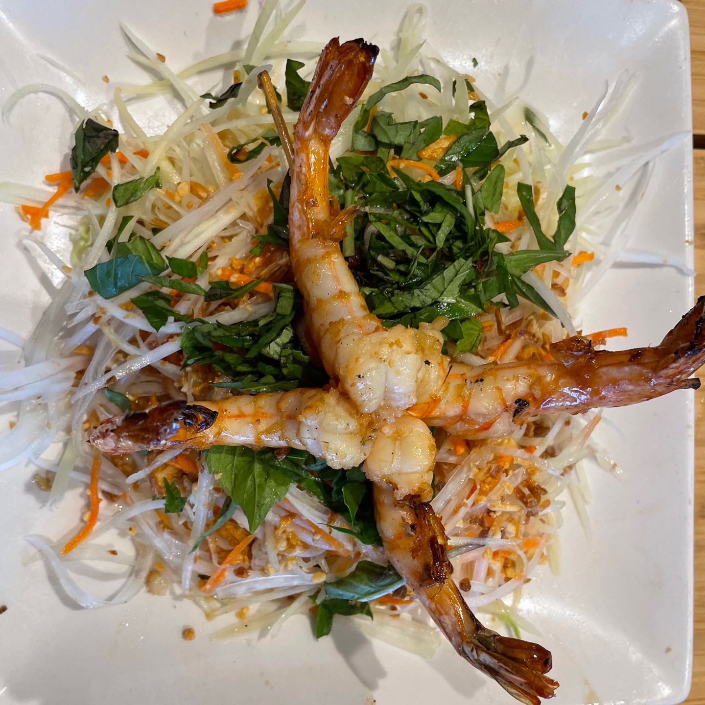 Shredded green papaya with shrimp, carrots, and Vietnamese coriander, tossed in tangy lime vinaigrette, topped with toasted peanuts & fried shallots.