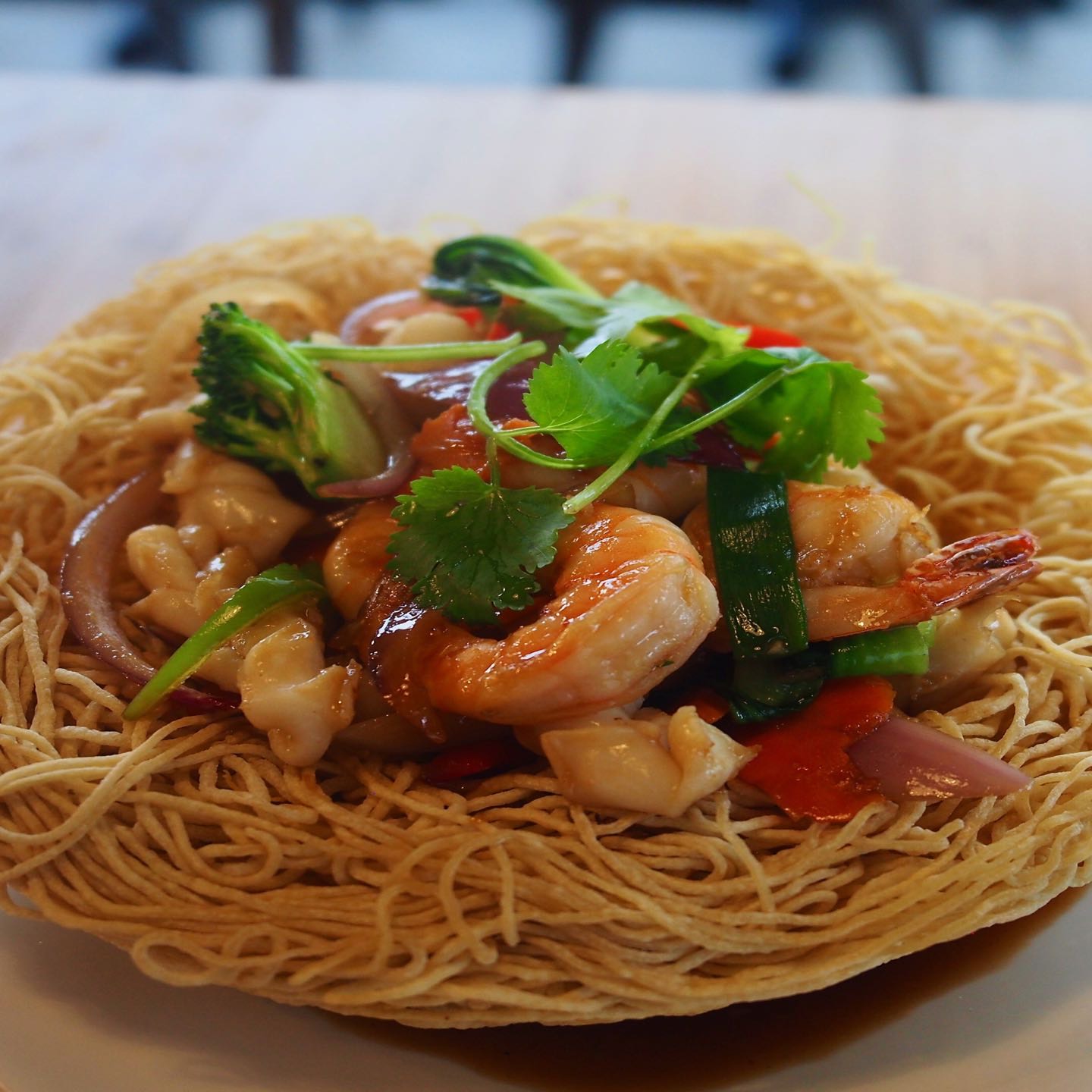 Stir-fried tiger prawns, calamari, mushrooms and garden vegetables tossed in rice wine and oyster sauce, served on a nest of crispy eggs noodles.
