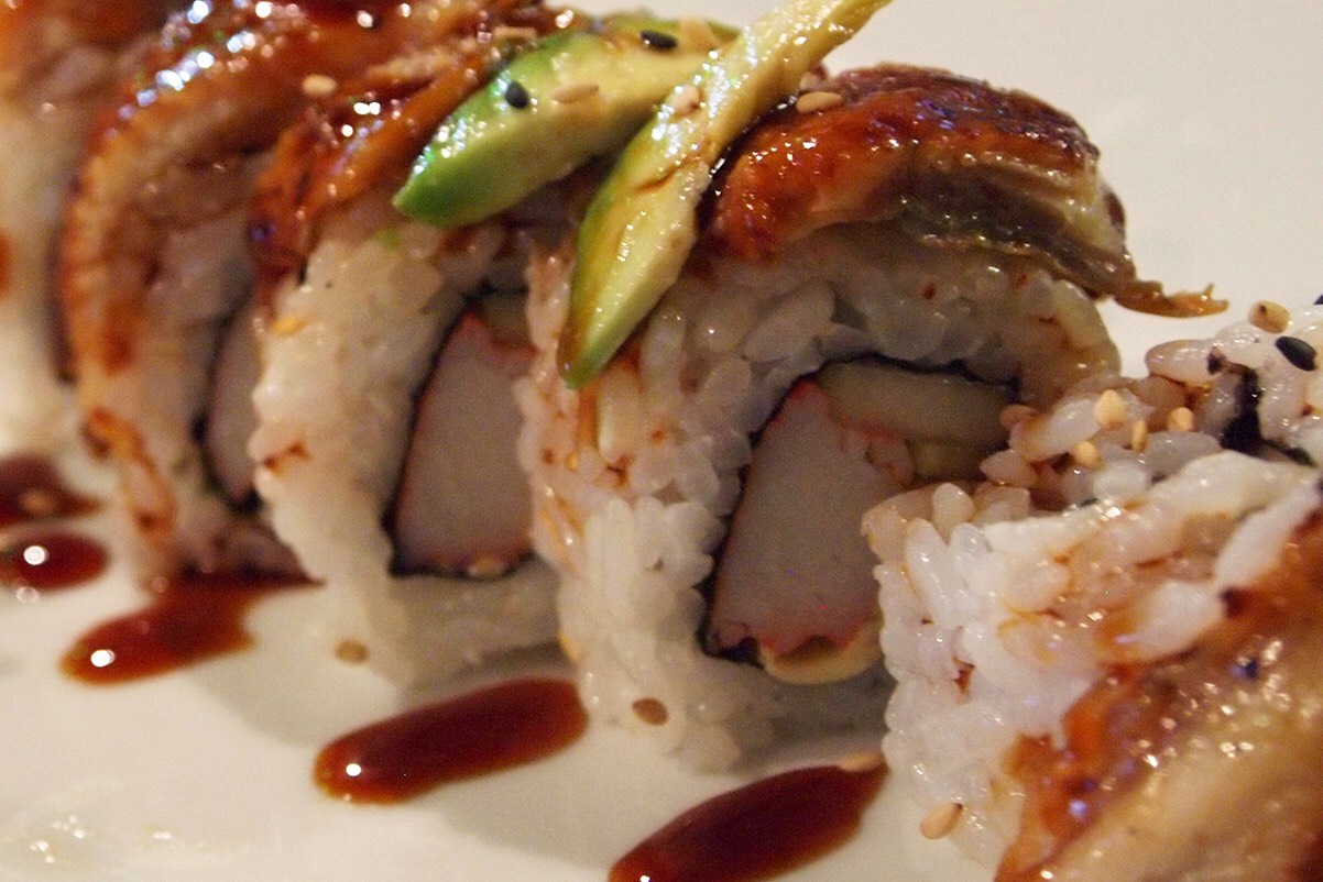 A California roll topped with avocado, unagi, and sweet sauce