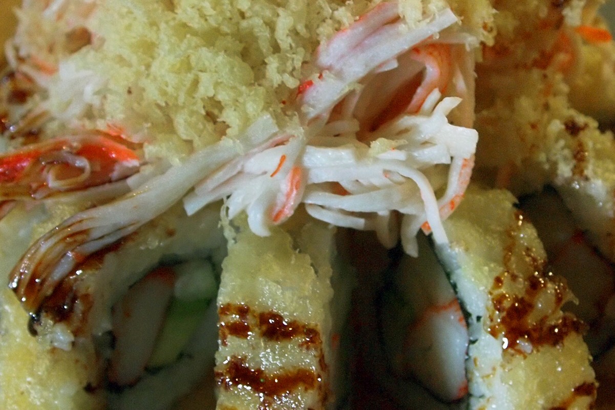 Tempura California Roll topped with Krab salad, tempura crunch, masago, and sweet sauce