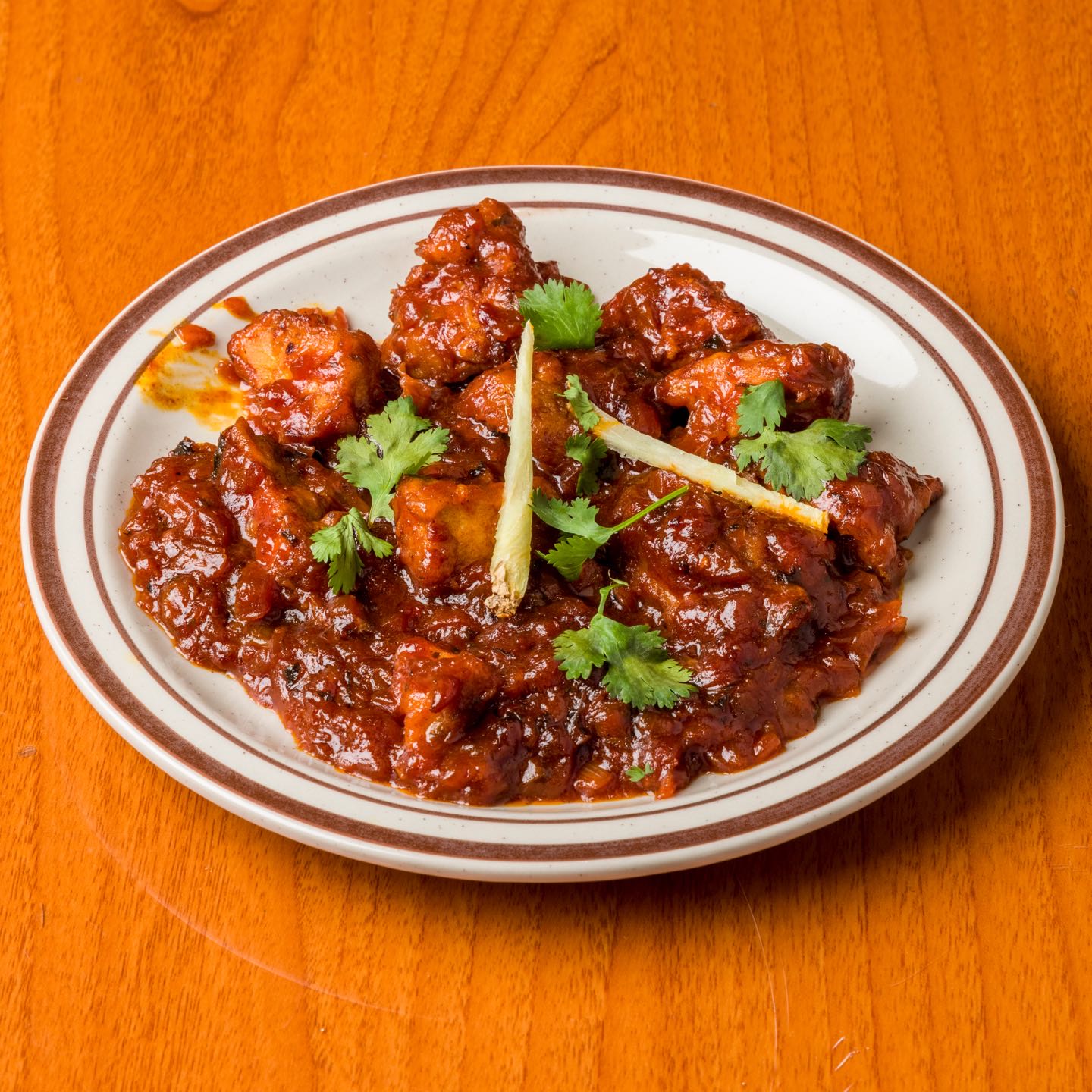Battered chicken florets, fried and cooked in sweet and sour sauce with onions and tomatoes.