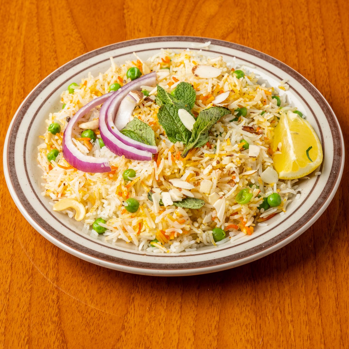 Basmati rice with fresh vegetables cooked with nuts, herbs, spices and seasonings. Served with Raita (yogurt with grated cucumbers and carrots).