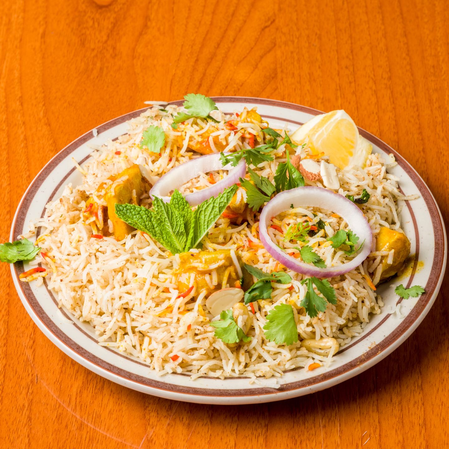 Chicken cooked with basmati rice in special spices and nuts, herbs and seasonings. Served with Raita (yogurt with grated cucumbers and carrots).