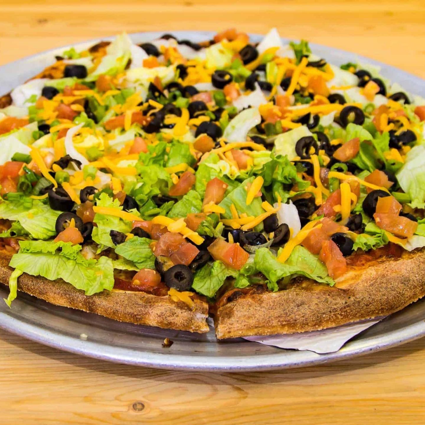 Taco Meat, Mozzarella Cheese, Lettuce, Black Olives, Fresh Tomatoes, Green Onions & Cheddar Cheese with our South of The Border Sauce.