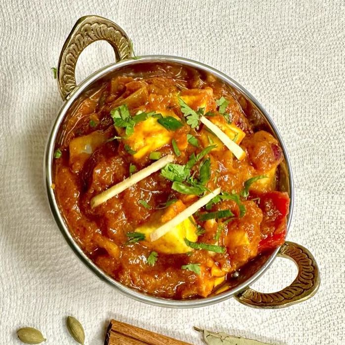 A savory Indian dish featuring succulent cubes of paneer cooked with bell peppers, onions, and aromatic spices in a thick tomato-based gravy. Served with steamed rice.