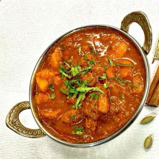 Tender lamb marinated in a tangy blend of vinegar, garlic, and fiery spices, slow-cooked to perfection, offering a tantalizing balance of heat and flavor. Served with steamed rice.