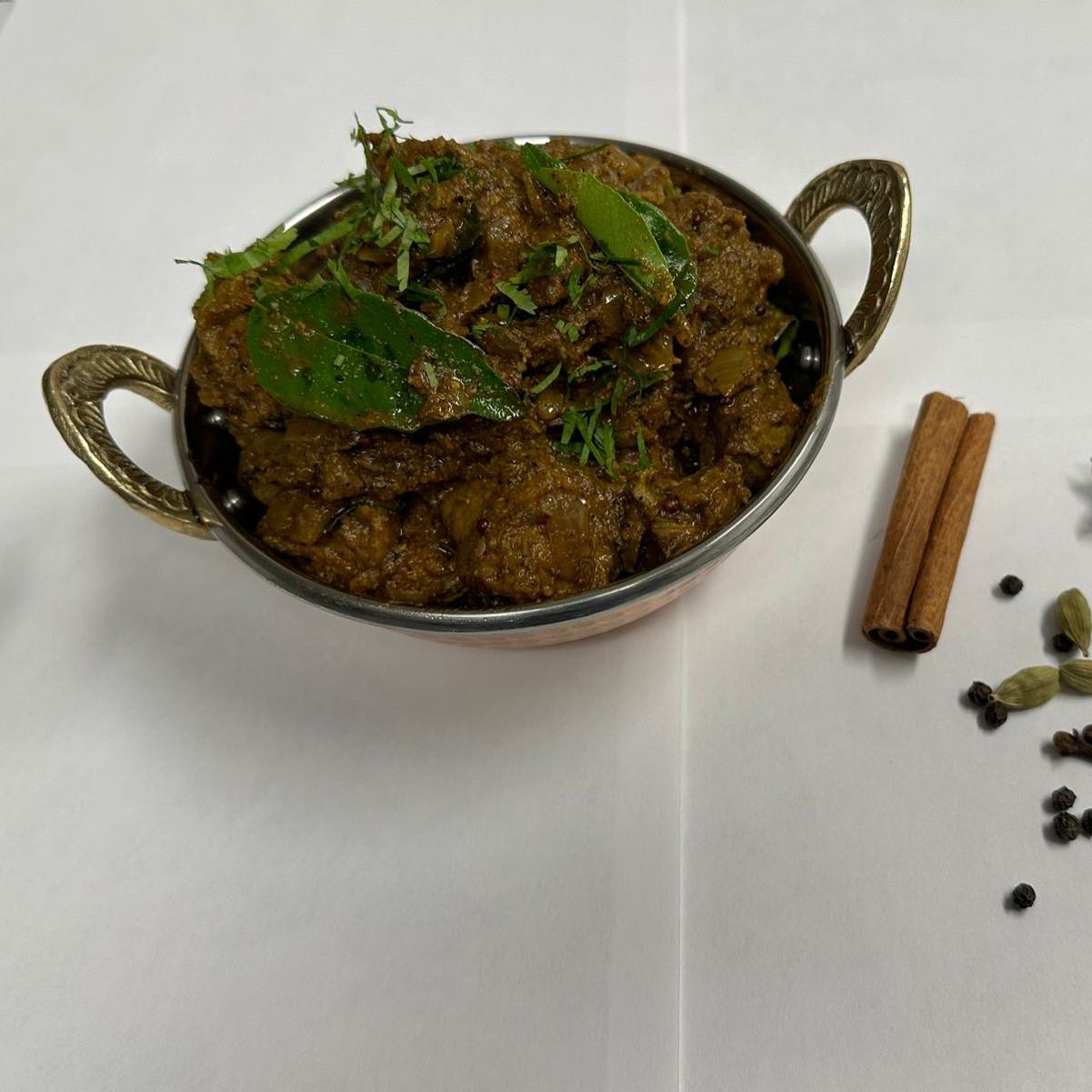 Tender goat meat sautéed with aromatic spices and cracked black pepper, delivering a bold and flavorful South Indian dish with a spicy kick. Served with steamed rice.
