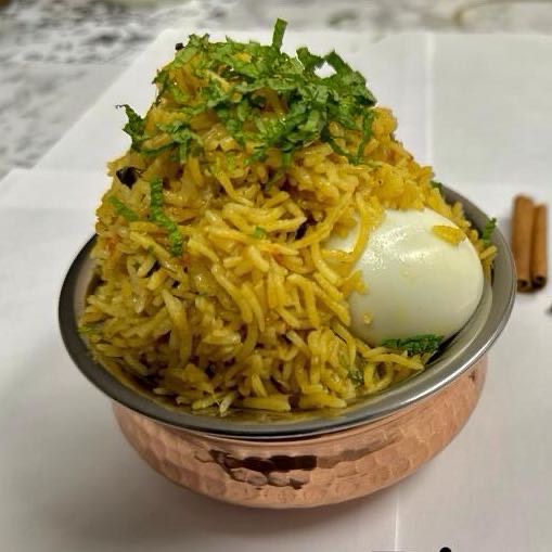 Soft-boiled eggs simmered in a spicy blend of Andhra spices, layered with fragrant basmati rice, delivering a fiery and flavorful twist on the classic biryani. Served with raita.