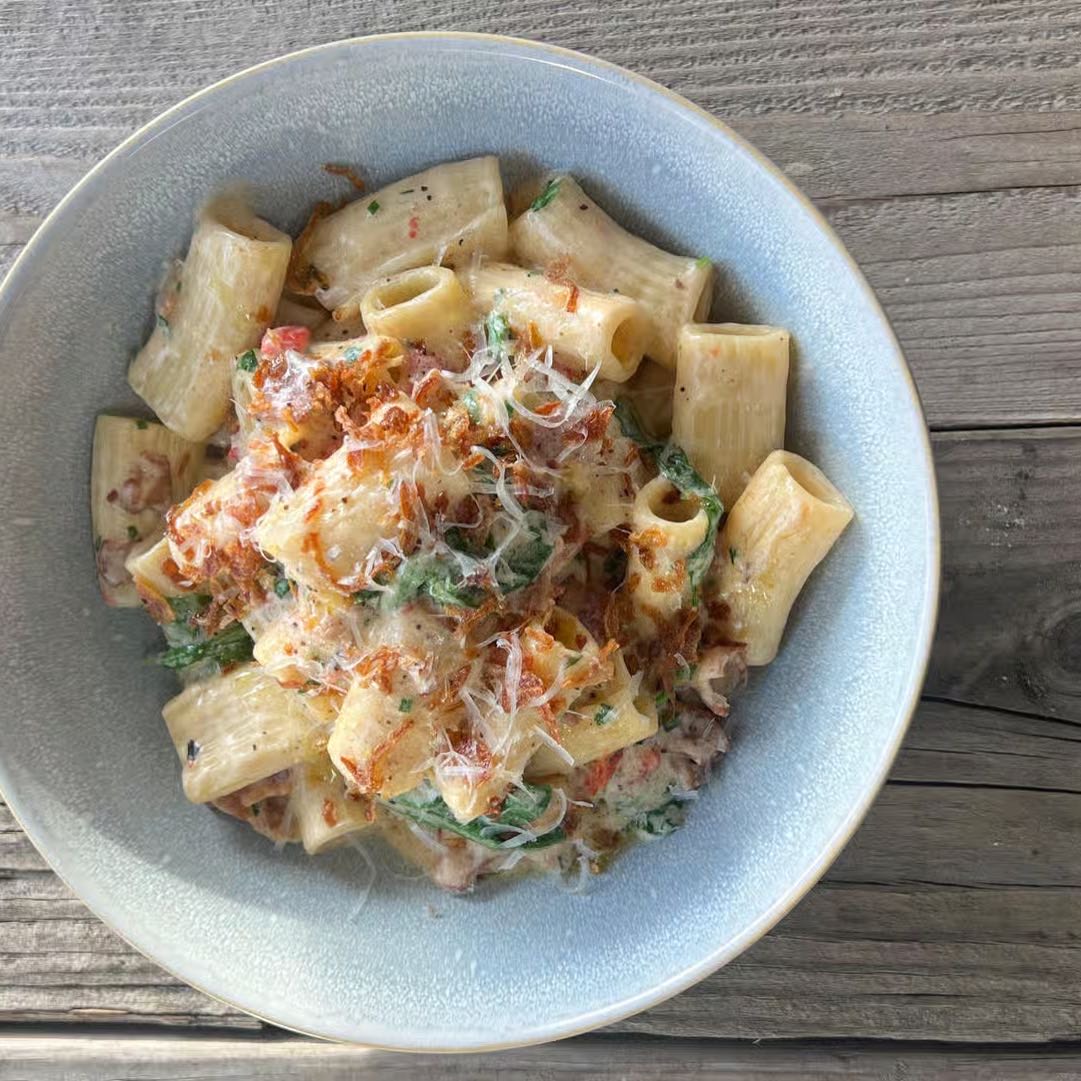 Short pasta in a truffle cream sauce, bacon, roasted sweet peppers, arugula, Reggiano, and fin herbs.