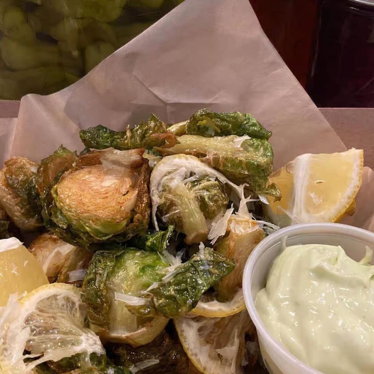 Deep fried cavolo piccolo (brussel sprouts) tossed in fresh herbs, garlic, evo, sea salt, grated Parmesan, fried lemon, and balsamic glaze. - FG Amore restaurant in Forest Grove, OR