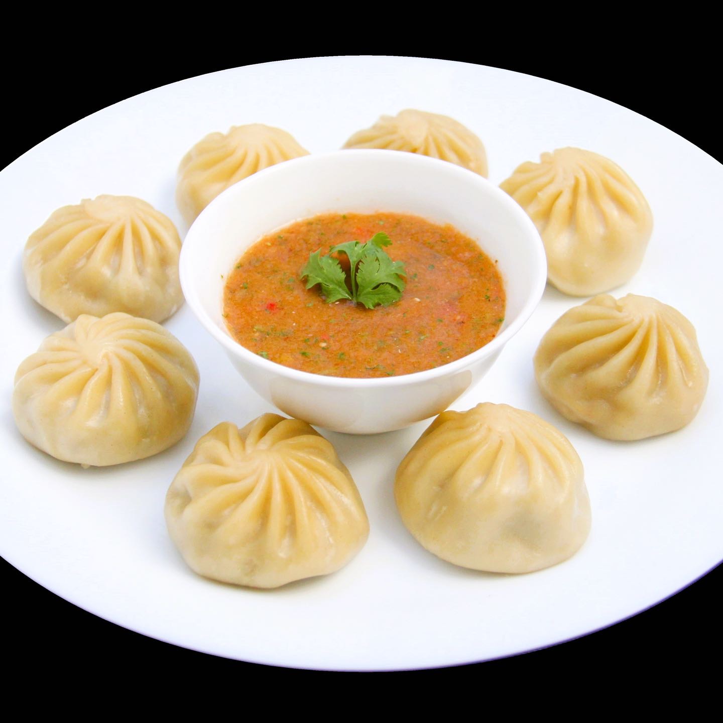 Famous Nepali steamed momo (dumplings) made from scratch, filled with a delectable mixture of vegetable protein or ground chicken blended with vegetables and aromatic Himalayan spices. Served with sauce.