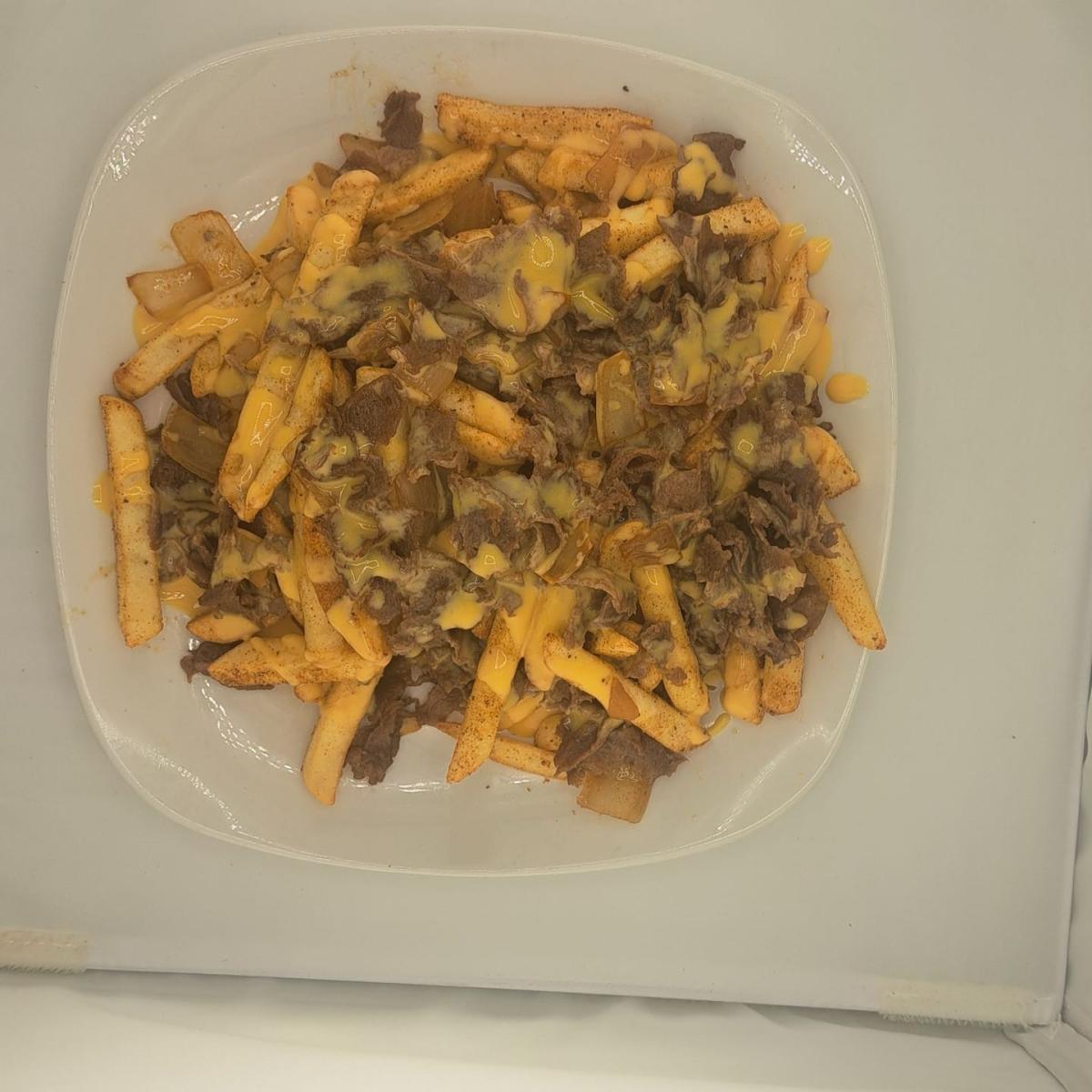Large order of Premium French Fries ( Regular, or Boardwalk) topped with steak and onions and Cheese sauce. - East Coast Eddie's Authentic Philly Cheese Steaks - Hillsboro restaurant in Hillsboro, OR