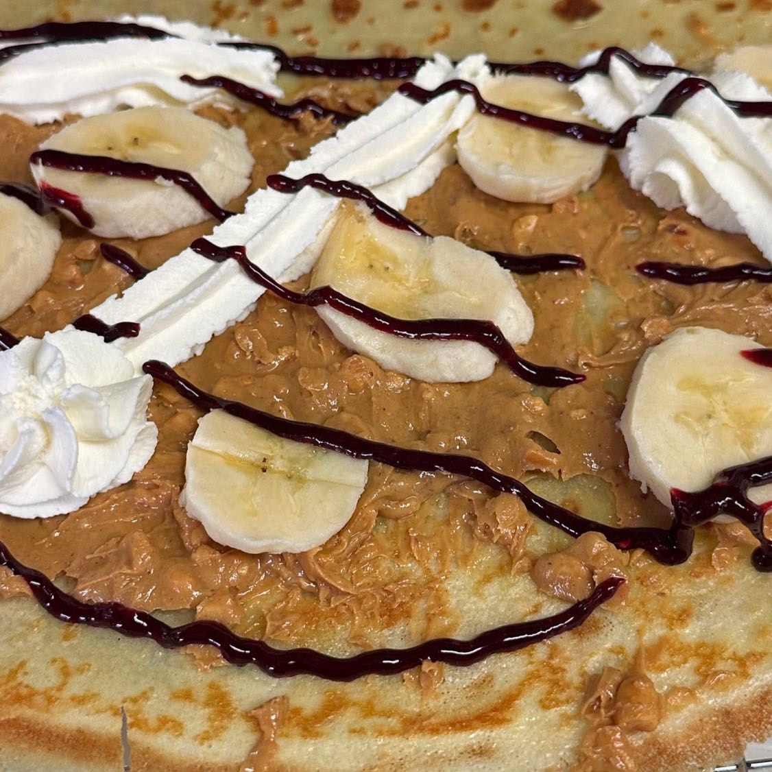 Carmalized bananas, cinnamon powder, whipped cream, candied walnuts & caramel drizzle.