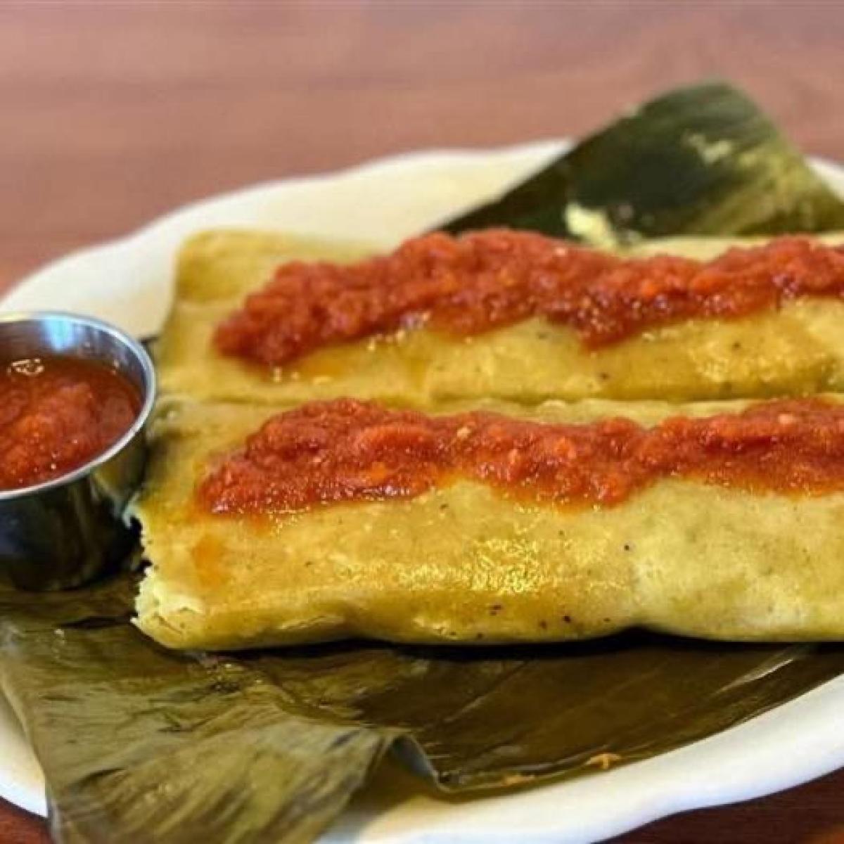 One chicken tamal with house tomato salsa.  Made with organic masa in banana leaves. - El Rinconcito Yucateco restaurant in Portland, OR