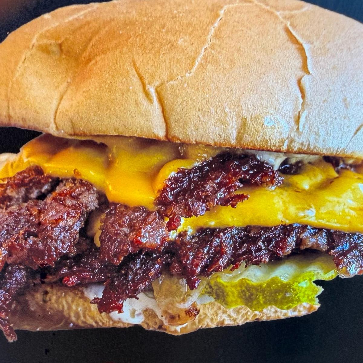 Comes with hamburger, house sauce, pickle, house slaw and cheese. Served with fries. - Singh Is King Smashburger restaurant in Beaverton, OR